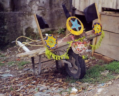 A wheel-barrow somebody went to some trouble to decorate with home-made ornaments.