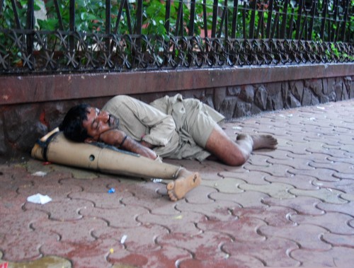 A man sleeping on his own prosthetic leg.
